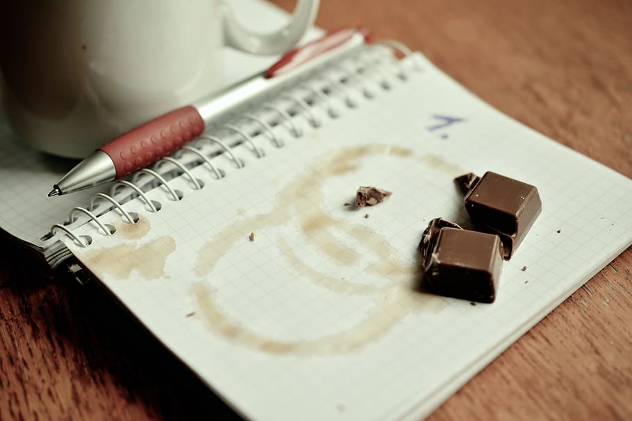 two brown chocolate bars on white book, notebook, plan, dates HD wallpaper