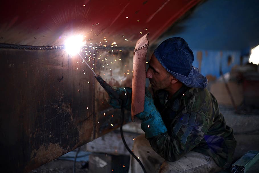 man using welding machine on metal, welder, work, mask, safety, HD wallpaper
