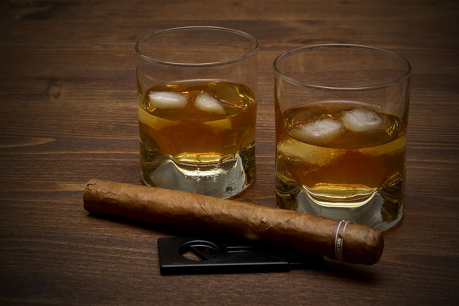 brown tobacco beside clear drinking glasses, whisky, alcohol