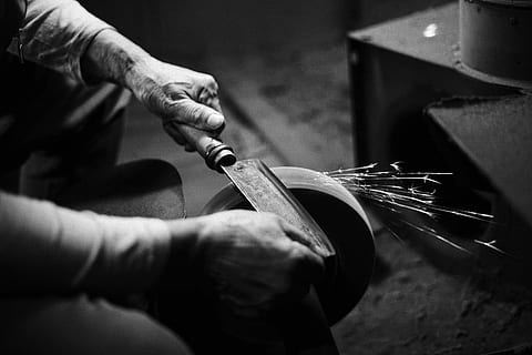 person grinding cleaver, person sharpening his knife on grinding disc HD wallpaper