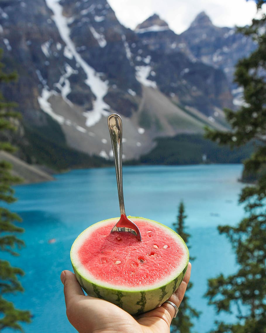 person holding slice of watermelon with fork, spoon pierced on watermelon HD wallpaper