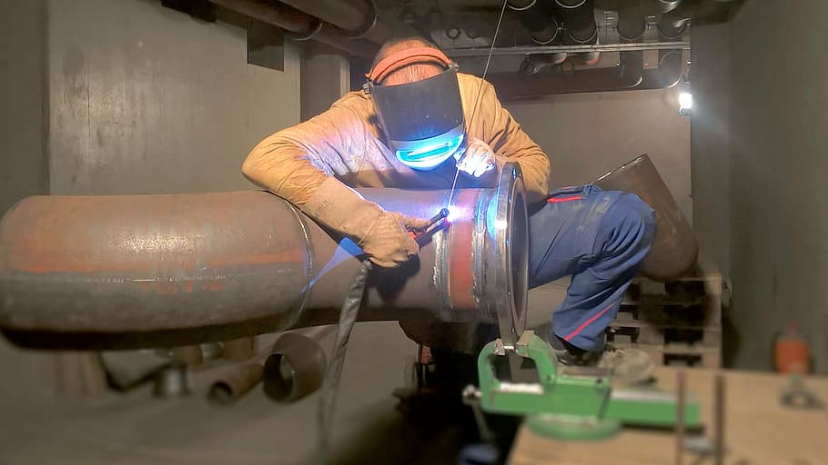 man repairing tube, weld, metalworking, welder, radio, factory