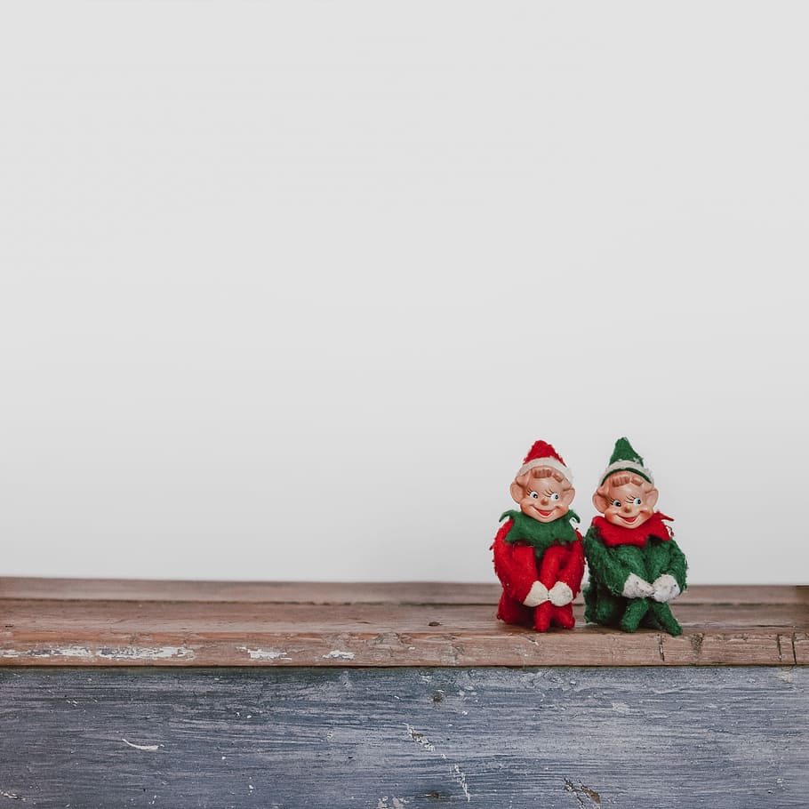 two elf on the shelf figurines, two dwarfs on brown surface, elves