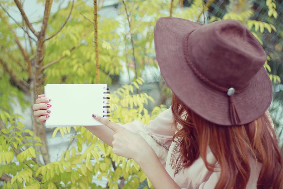 human holding white spiral notebook during daytime, women, outdoors HD wallpaper