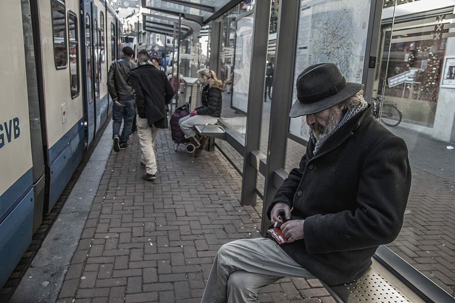 man sitting on waiting bench in train station, man sitting on bench of train station HD wallpaper