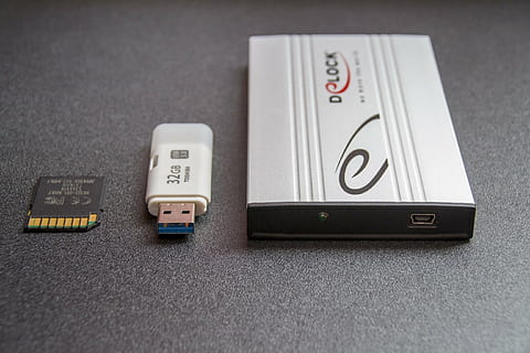 closeup photo of gray external hard drive beside white 32 GB flash drive HD wallpaper