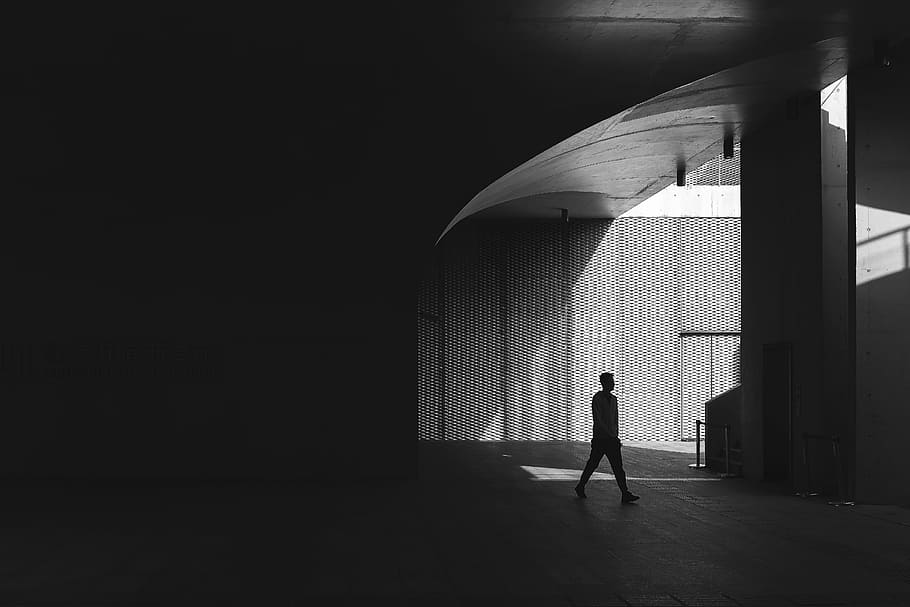 silhouette photography of man walking on floor beside post, grayscale photo of man standing near wall, HD wallpaper