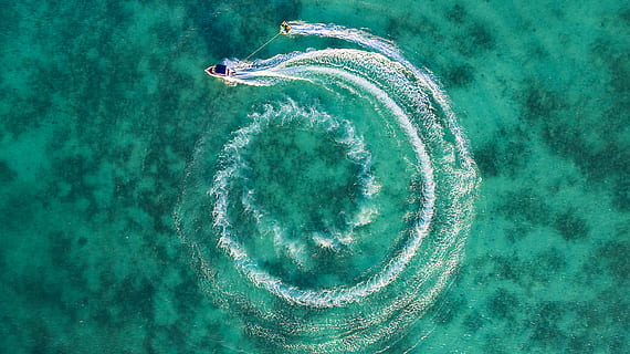two boats on calm body of water top-view photography, speedboat maneuvering on body of water while pulling person on wakeboard HD wallpaper