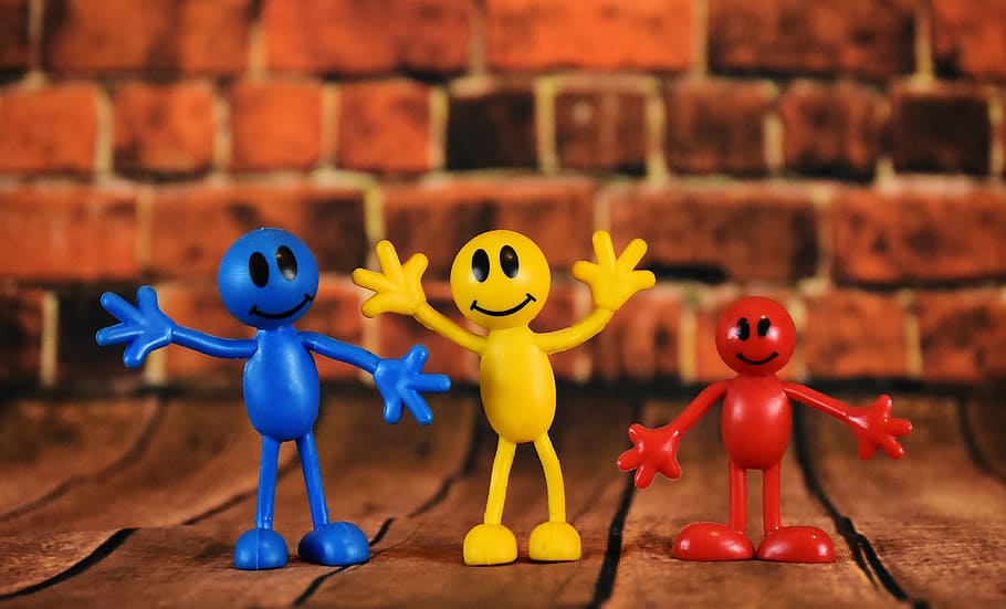 three blue, yellow, and red plastic smiley emoji toys, smilies