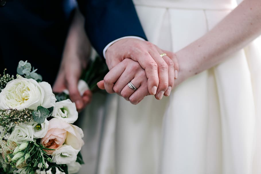 close up photo of man holding woman's hand, woman wearing silver-colored rings HD wallpaper