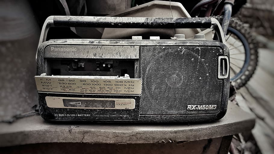 Discarded cassette player, black radio on table, broken, old