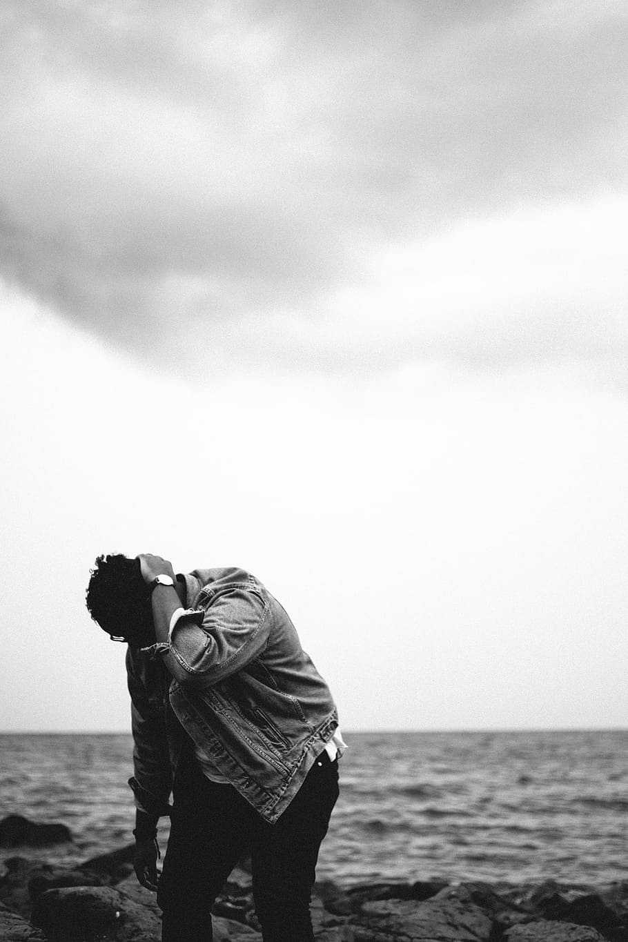 grayscale photography of person looking down at rocks, grayscale photo of man standing near seashore HD wallpaper