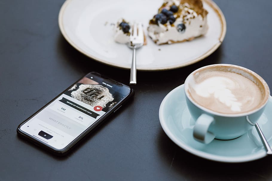 teal ceramic teacup on saucer beside black smartphone, cake on round white ceramic plate beside teacup and saucer HD wallpaper