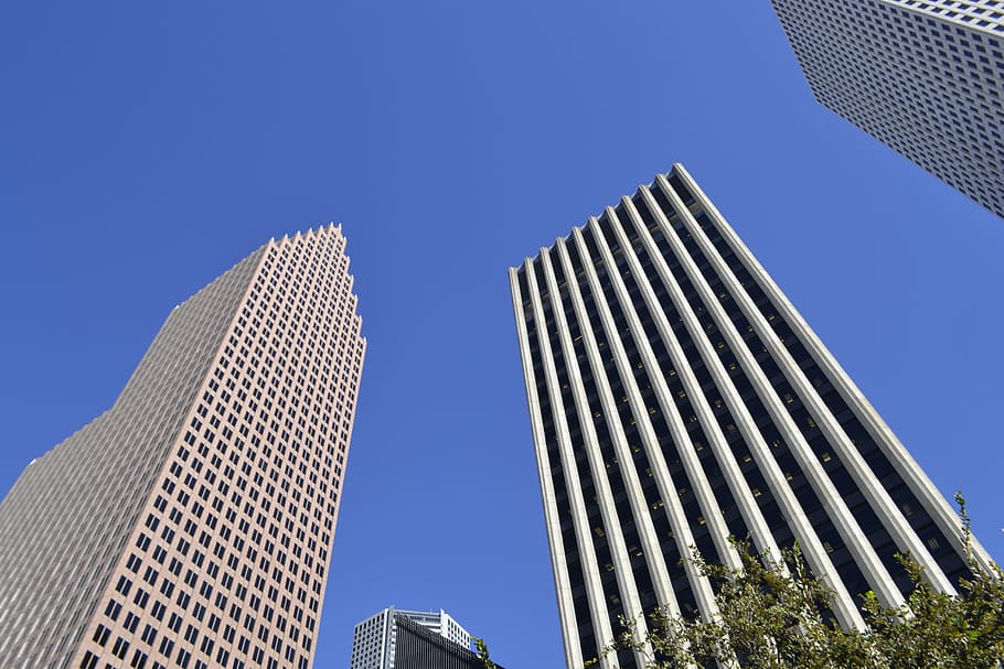 bottom view of concrete buildings under blue sky, skyscrapers