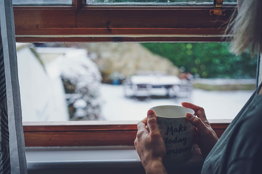 person holding white ceramic mug, woman holding mug while facing on window HD wallpaper