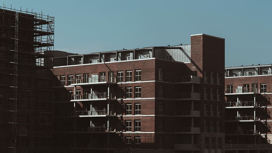 city building under clear sky, photo of brown buildings during daytime HD wallpaper