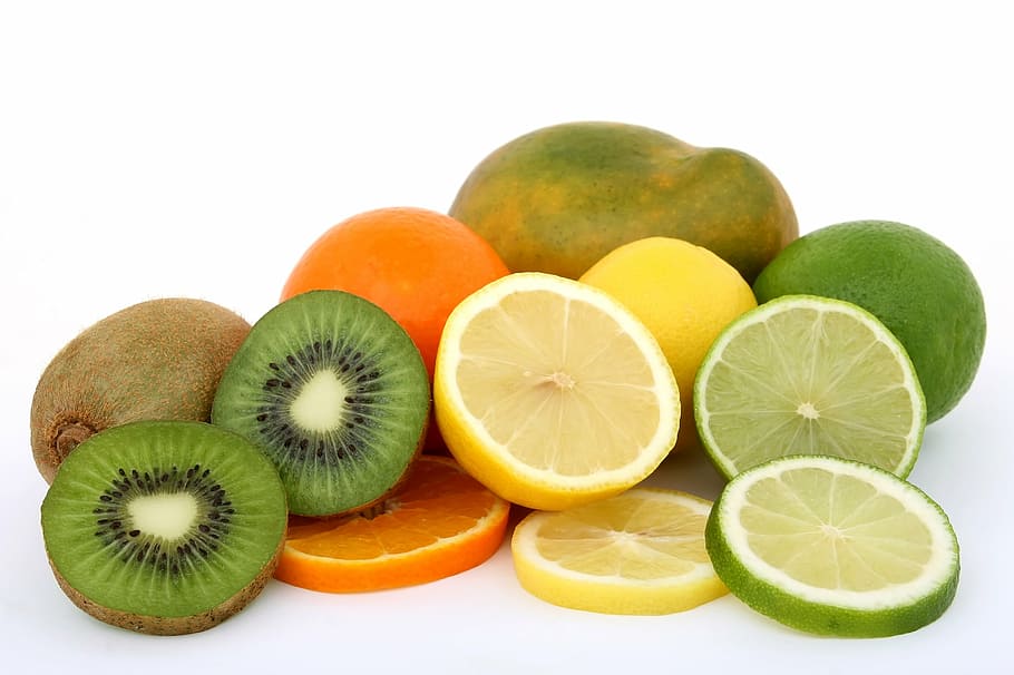 sliced kiwi, orange, lemon, and green papaya fruits, background