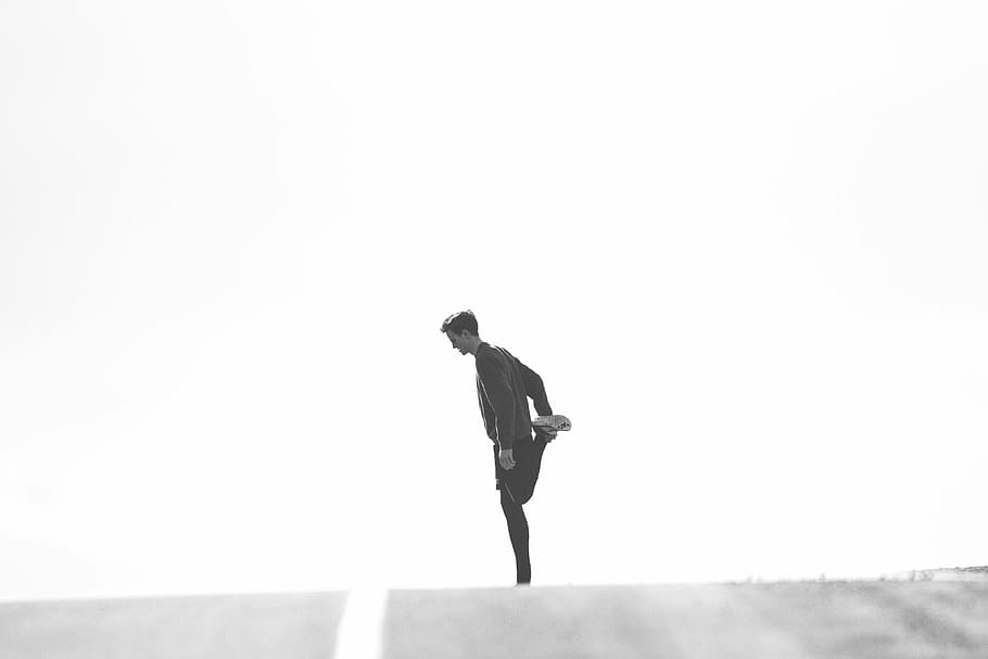man in black suit doing leg stretching in grayscale photography HD wallpaper