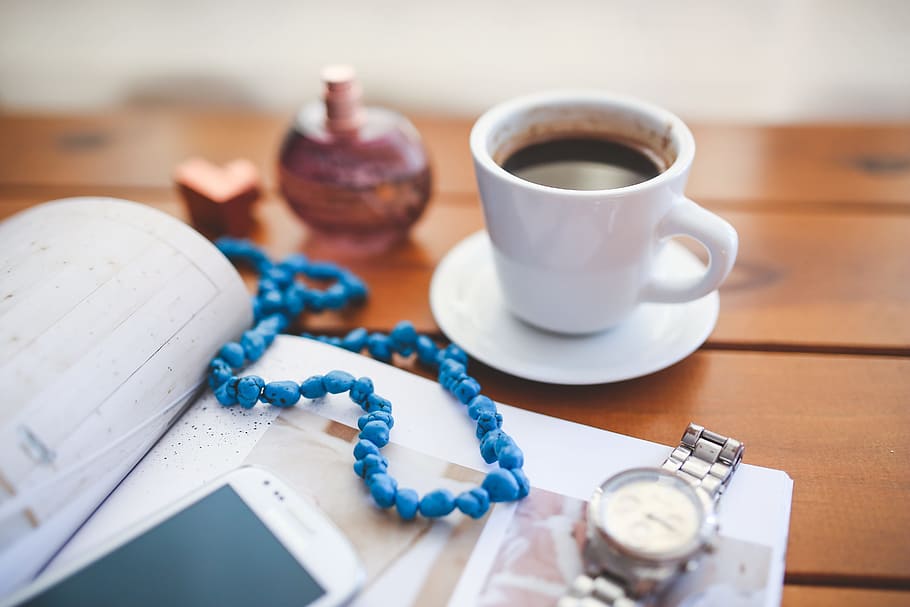 beaded blue necklace on book between white cup with coffee and analog watch HD wallpaper