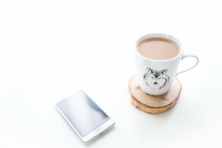 white and black wolf-printed ceramic mug on top of brown cordwood beverage coaster HD wallpaper