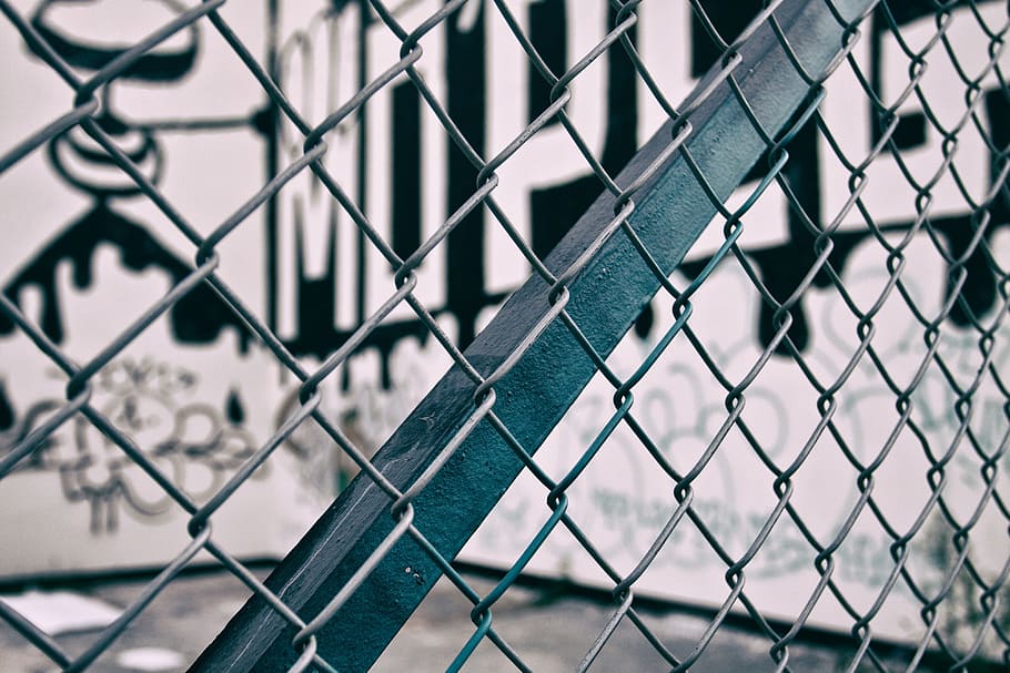 Close-up shot through a urban metal fence, graffiti, street Art