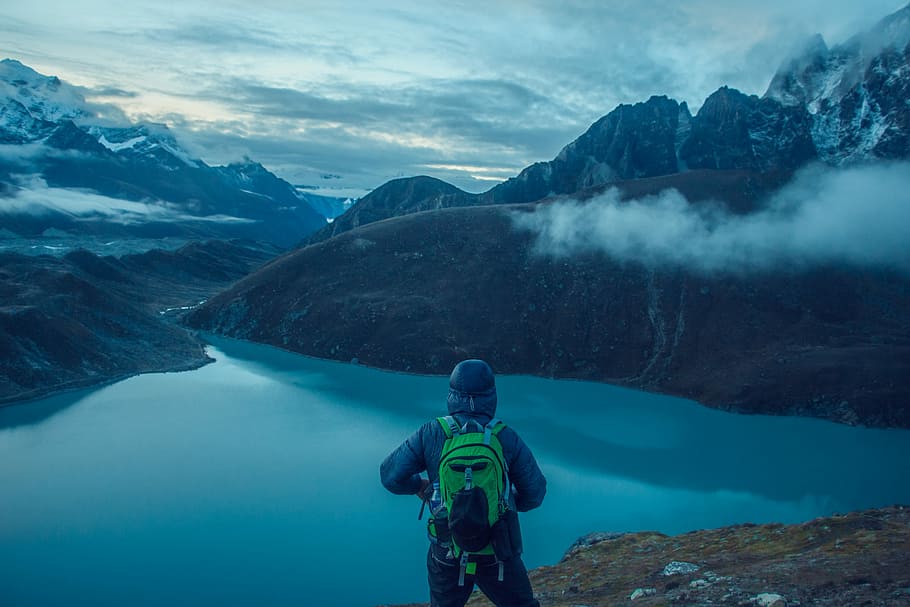 person facing lake surrounded with mountains photo, person standing in front of river HD wallpaper