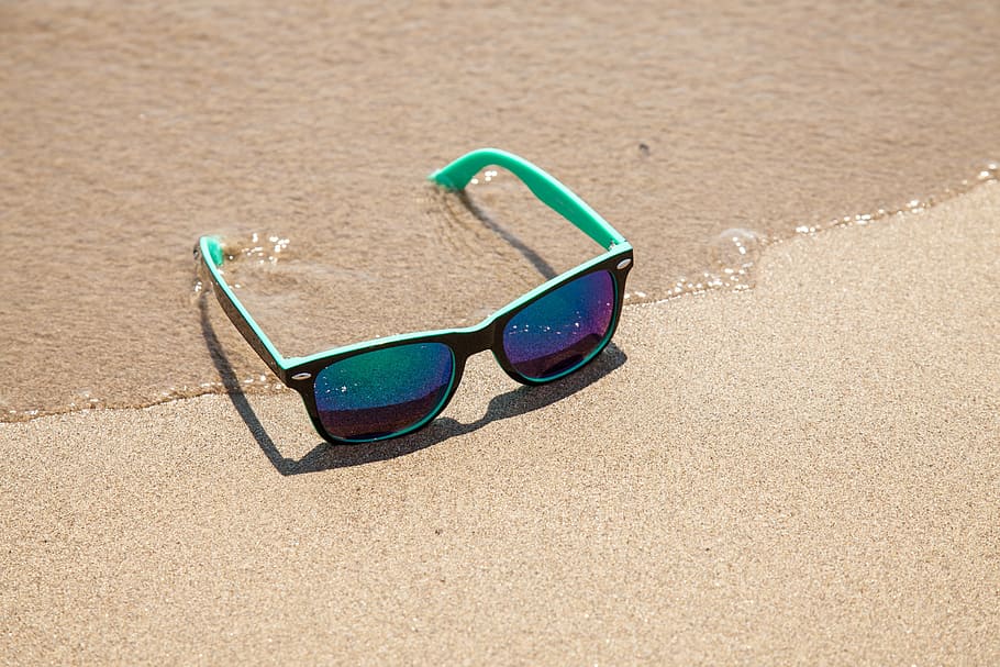 black framed Justin sunglasses on sand, sun protection, beach