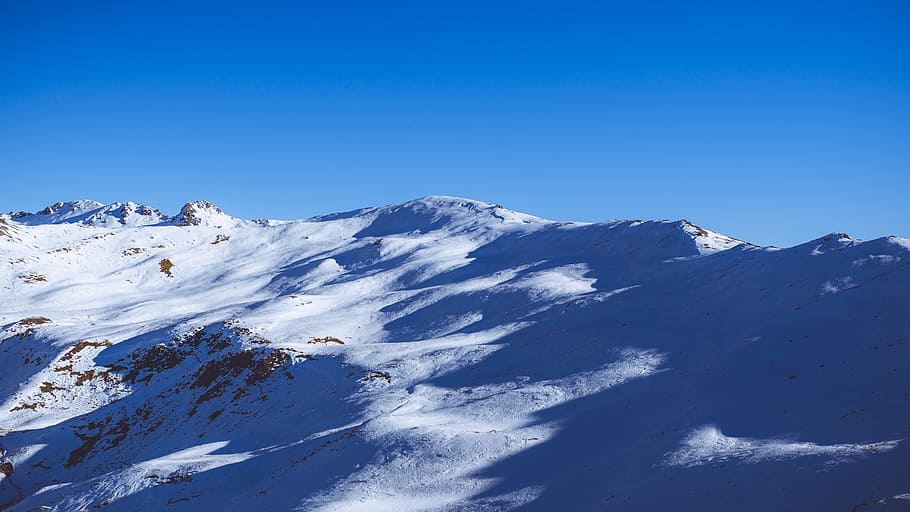 landscape photography of mountain, aerial photography of snow covered mountain under blue sky at daytime HD wallpaper