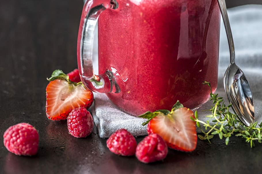 sliced strawberries and raspberries beside clear glass pitcher HD wallpaper