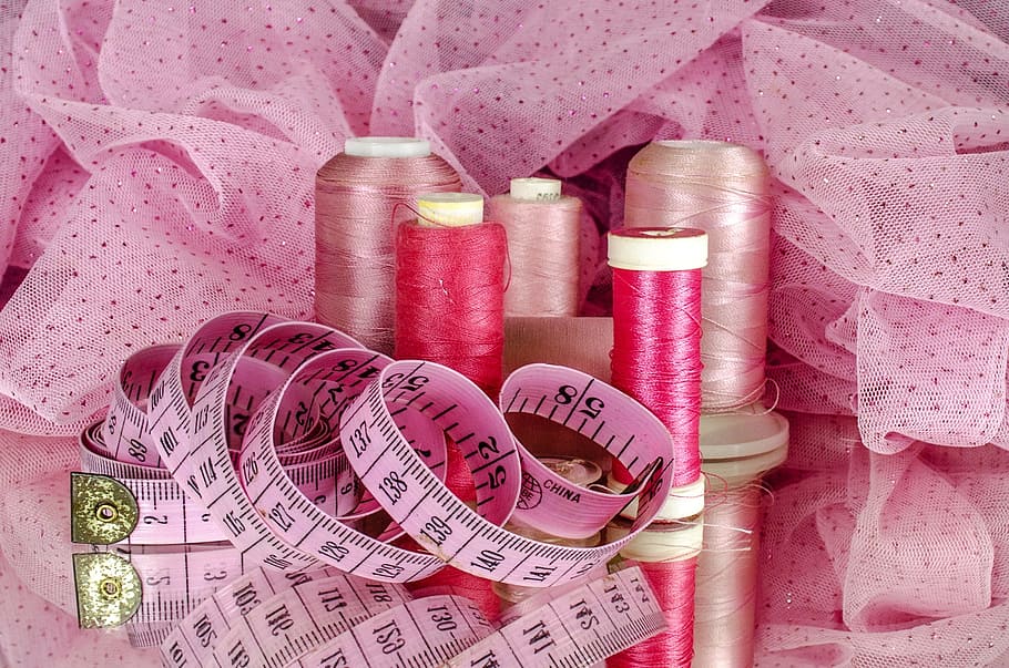 sewing thread and tape measure on ribbon, cotton, material, pink