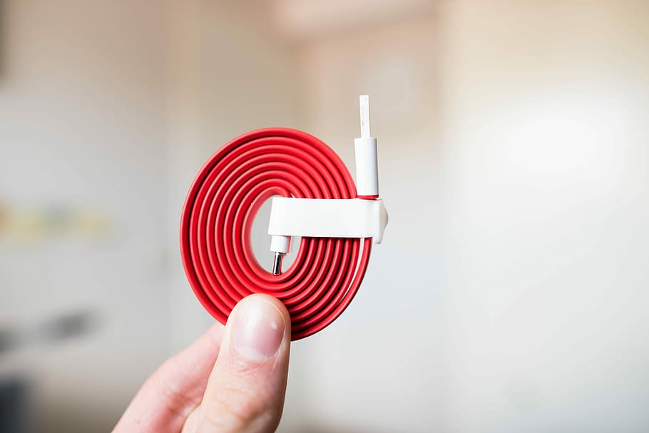 person holding white and red cable, person holding red USB cable HD wallpaper