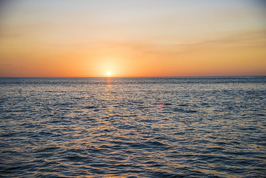 ocean water during sunset, sun on horizon, sky, sea, beauty in nature HD wallpaper