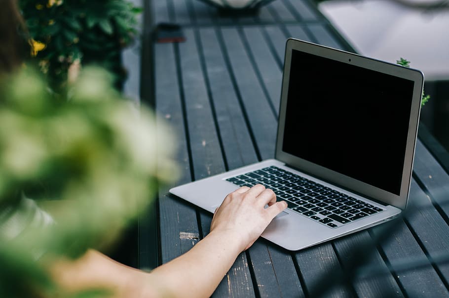 person holding turned off laptop, person in front of laptop at daytime HD wallpaper