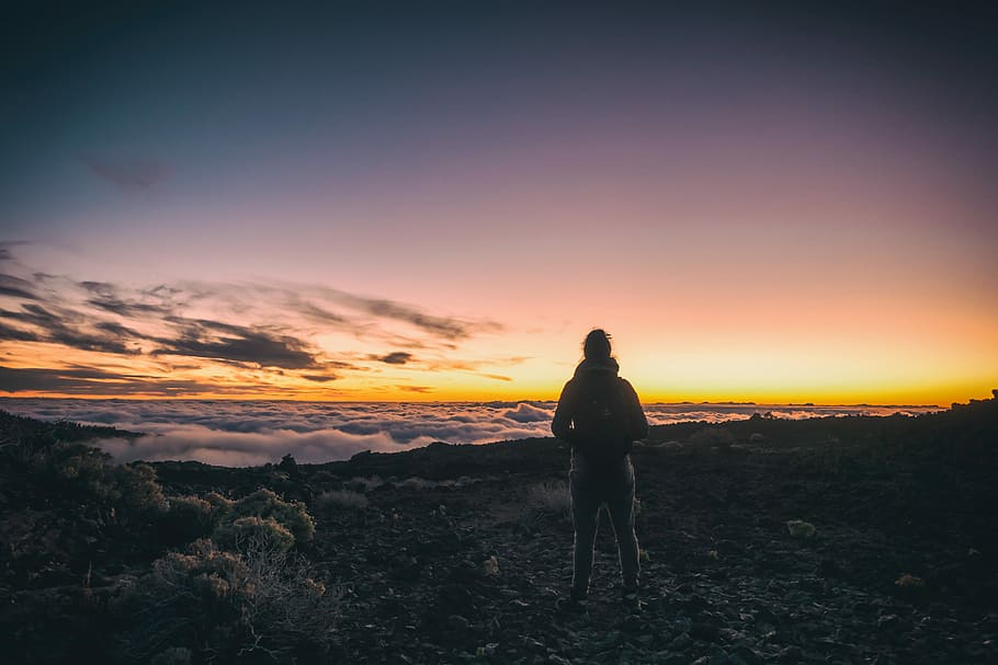 man standing on top of mountain, person standing on top of a mountain above the clouds during sunset HD wallpaper