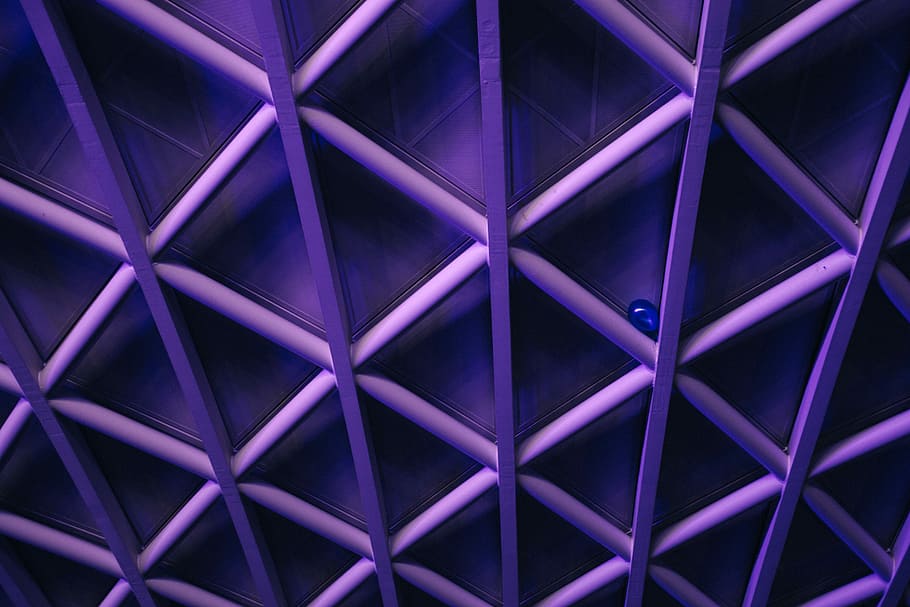 A violet ceiling with a criss-cross pattern; a blue balloon is stuck in the corner one of the crossbars, purple frame ceiling