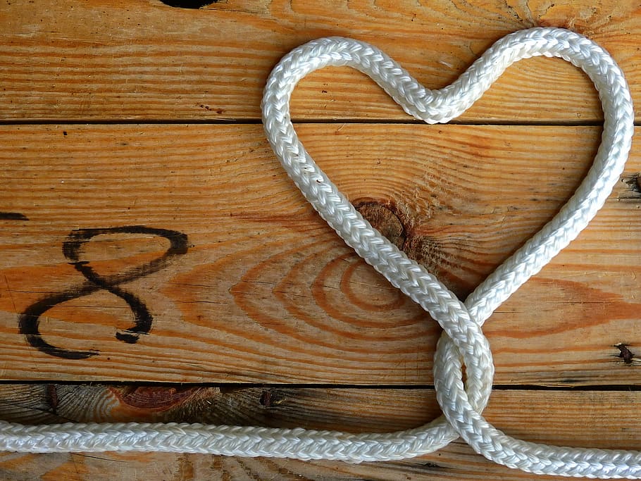 flat lay photography of heart formed white rope, loop, wood, connected
