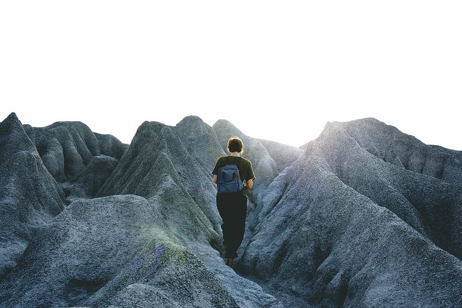 photo of man walking on mountain, rocks, male, backpack, sun flare HD wallpaper