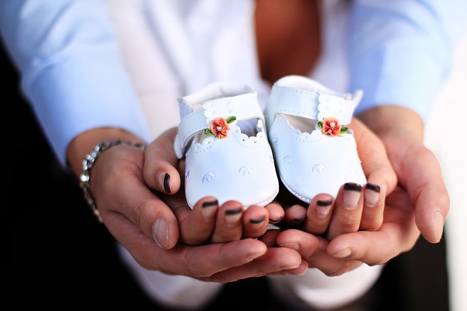 close-up photography of pair of baby's white leather shoes on persons hand HD wallpaper