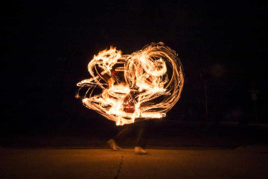 timelapse photo of steel wool on fire, timelapse photography of a person performing fire art