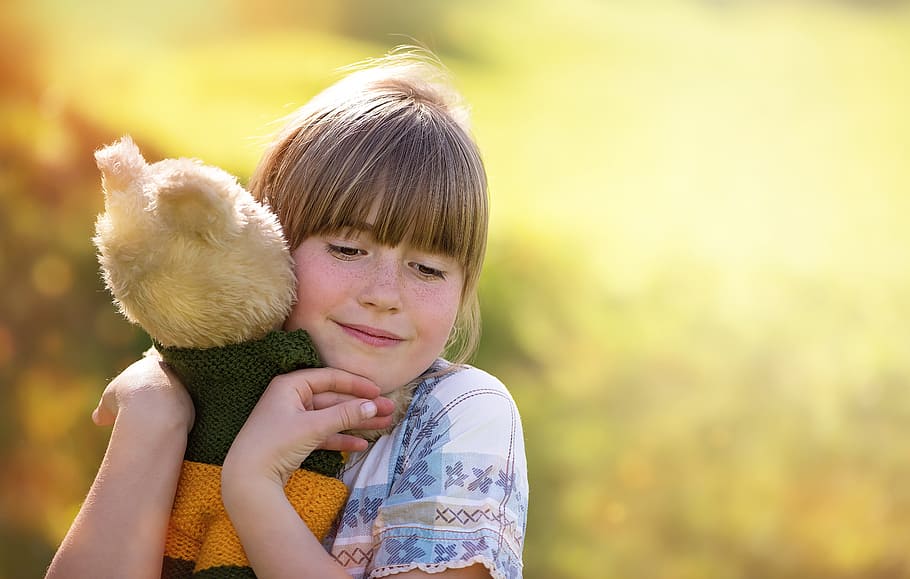 selective focus photography of girl hugging bear plush toy HD wallpaper