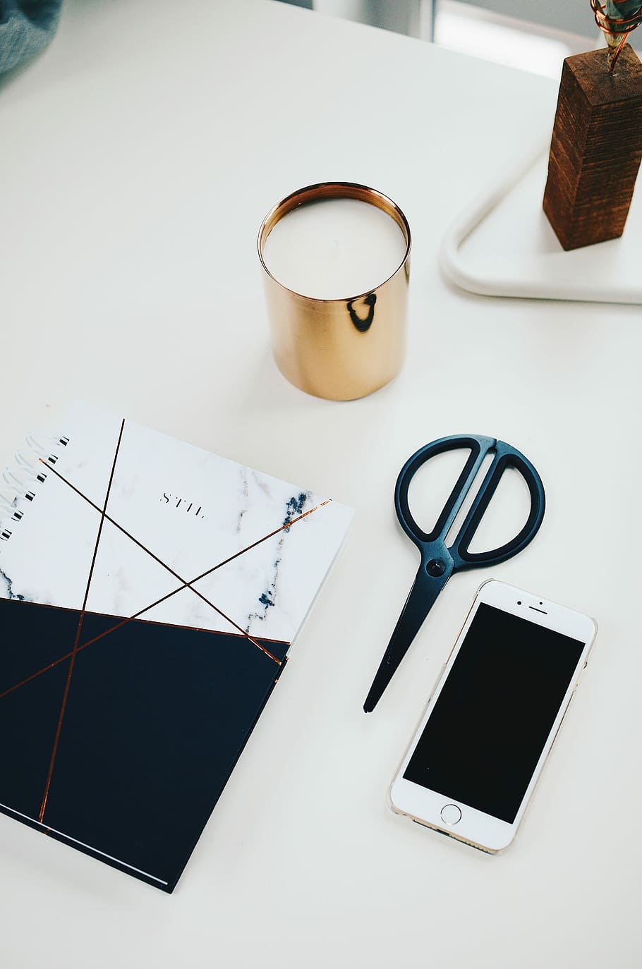 silver iPhone 6 beside black scissors and white and black notepad on white table, black scissors beside gold iPhone 6 HD wallpaper