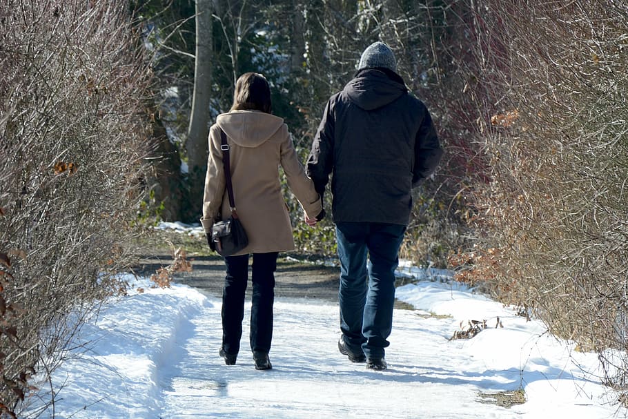 man and woman holding hands while walking during daytime, winter HD wallpaper