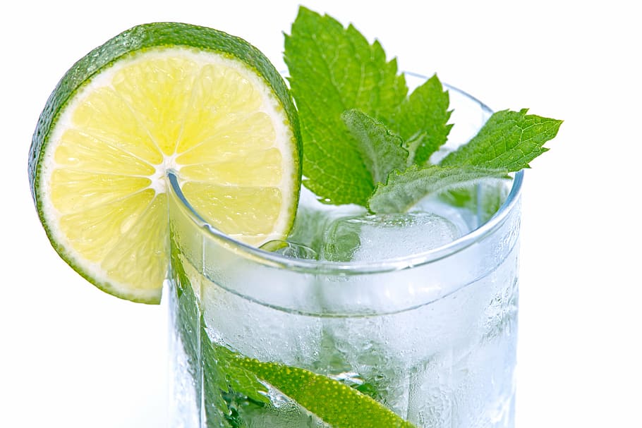 green leaf and sliced lime on clear glass drinking cup, cold drink