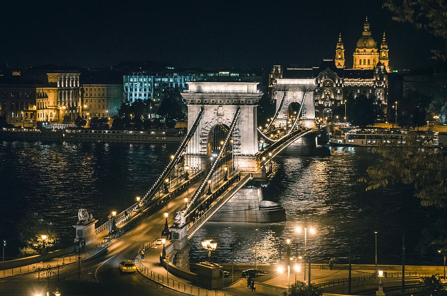 aerial photography of lighted concrete bridge, brown bridge near buildings during nighttime HD wallpaper