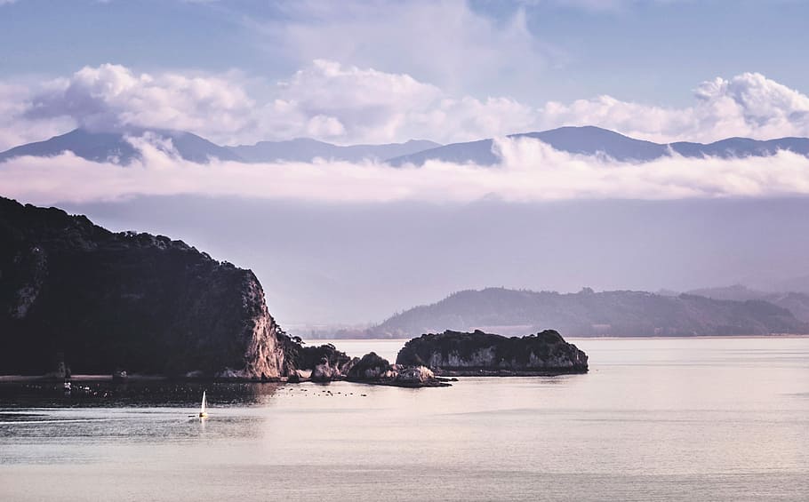 cliff on beach under cumulus clouds, mountain near body of water HD wallpaper
