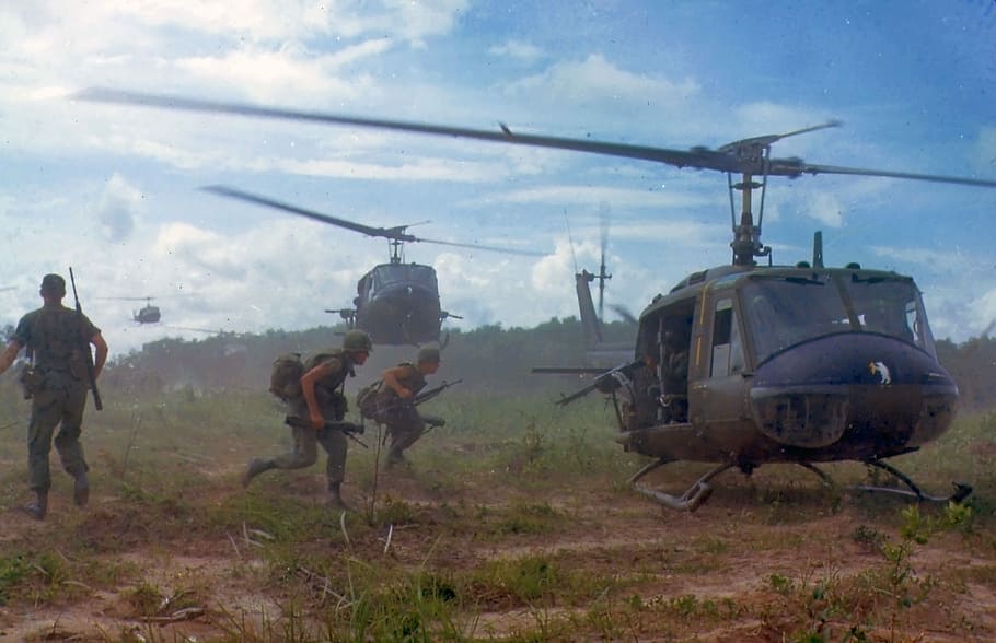 soldier on field riding on helicopter, military, vietnam war