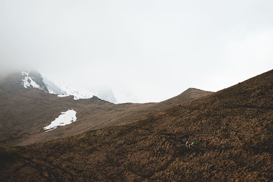 soil covered hills during day, brown mountains during foggy daytime HD wallpaper