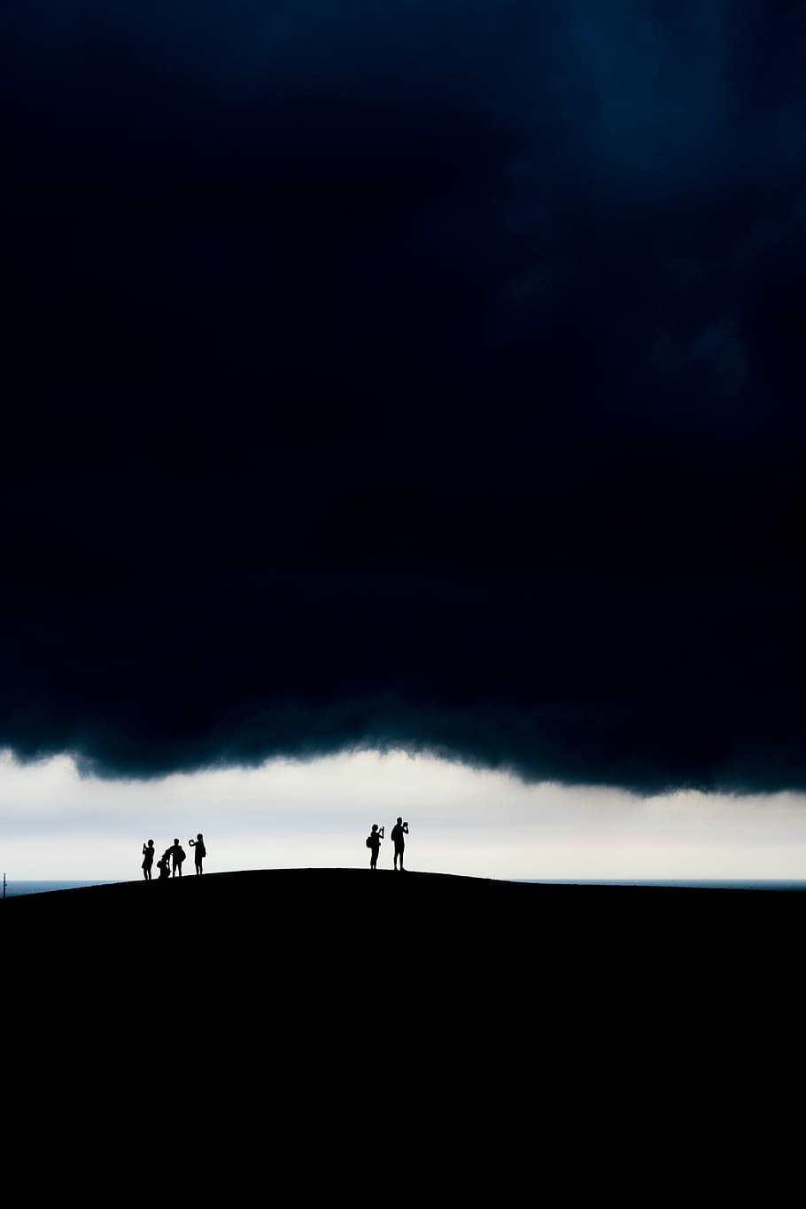Dark clouds, six people standing against white clouds, horizon HD wallpaper
