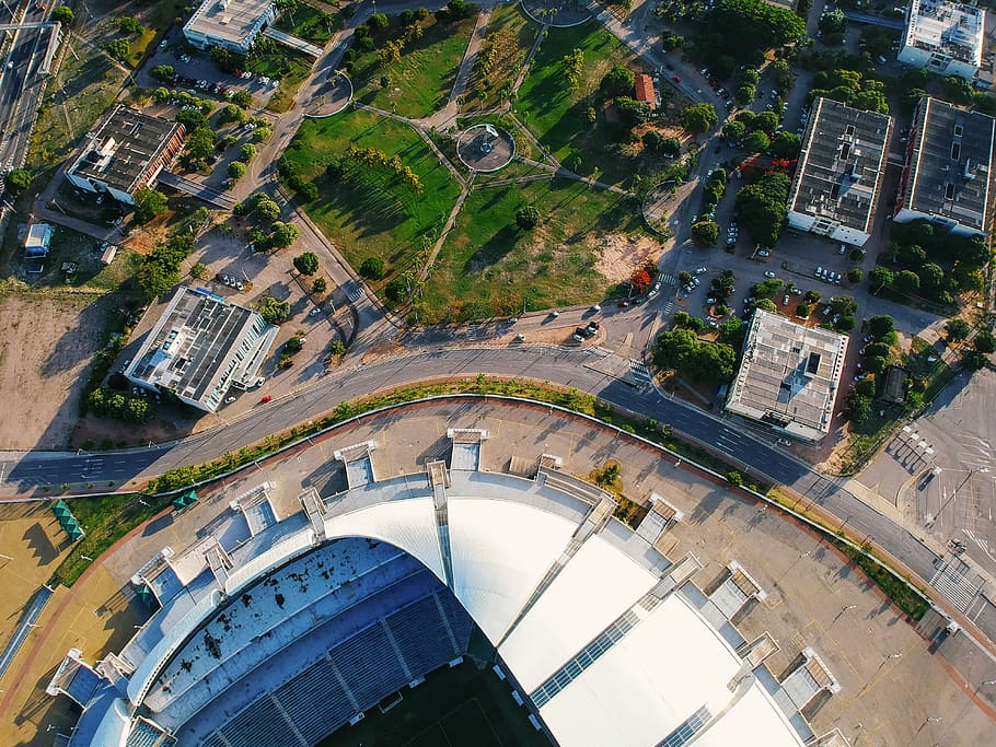 aerial photography of stadium, aerial photography of concrete buildings and road at daytime