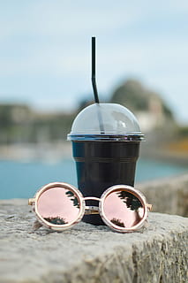 selective focus photography of black plastic cup beside sunglasses HD wallpaper